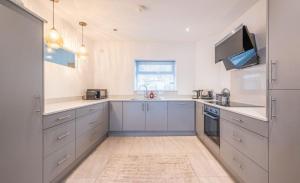 a kitchen with blue cabinets and a sink at Promenade Apartment Panoramic sea Views Portstewart in Portstewart