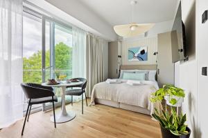 派尔努Tempus Te apArts Pärnu with balcony的一间卧室,配有一张床和一张桌子和椅子