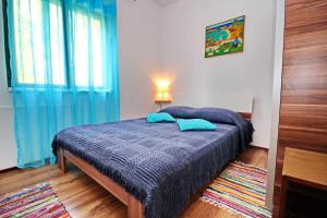 sypialnia z łóżkiem z niebieską pościelą i oknem w obiekcie Apartments Sunset w mieście Blato