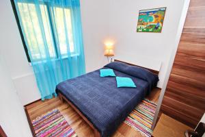 a bedroom with a bed with blue sheets and a window at Apartments Sunset in Blato