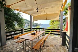 a table and benches on a patio with a view of the ocean at Apartments Sunset in Blato