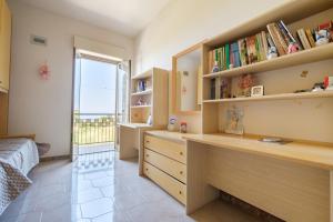 - une chambre avec un lit et un bureau avec des livres dans l'établissement Casa Stella vista Eolie, à San Pier Niceto