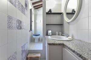 bagno bianco con lavandino e servizi igienici di Il Borgo a Capoliveri