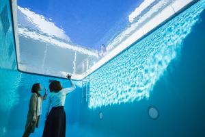two women standing in front of a swimming pool at Guesthouse Namaste in Kanazawa
