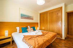 um quarto com uma cama grande e uma cabeceira em madeira em BeGuest Jardins Vale Parra Apartment em Albufeira