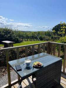 a table with a plate of food on a balcony at A Unique & Tranquil Smallholding Retreat in Redruth