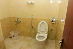 a bathroom with a toilet and a shower at Amity Inn in Kodaikānāl +10 photos