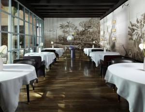 una fila de mesas en un restaurante con ropa de cama blanca en Palazzo Venart Luxury Hotel, en Venecia