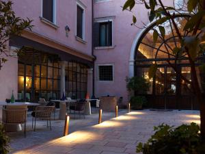 une cour avec des tables et des chaises dans un bâtiment dans l'établissement Palazzo Venart Luxury Hotel, à Venise