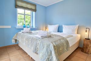 um quarto azul com uma cama grande e 2 toalhas em Hardina Whg 3, Stockmannsweg em Wyk auf Föhr