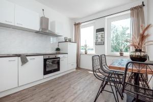 a kitchen with white cabinets and a table and chairs at Dream for 4 - Smart TV in Krefeld