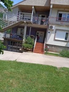 a house with a porch and stairs and a balcony at Villa Natalija in Podgorica