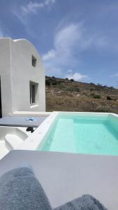 a swimming pool in front of a white house at Maeva Suites Santorini in Pirgos