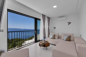- un salon avec un canapé blanc et une grande fenêtre dans l'établissement Premium Serenitas Ponti Apartment, à Brela