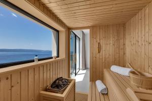 - un sauna avec une baignoire, un lavabo et une fenêtre dans l'établissement Premium Serenitas Ponti Apartment, à Brela