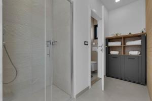 La salle de bains est pourvue d'une douche avec une porte en verre. dans l'établissement Premium Serenitas Ponti Apartment, à Brela