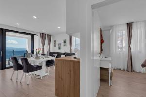 uma cozinha e sala de estar com mesa e cadeiras em Premium Serenitas Ponti Apartment em Brela