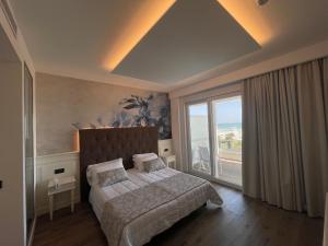 a bedroom with a bed and a large window at Park Hotel Cellini in Lido di Jesolo +102 photos