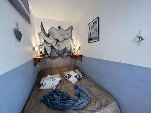 a small bed in a corner of a room at Studio Cabine 4 Couchages avec Balcon et Parking - Saint-Jean-de-Monts - FR-1-224C-18 in Saint-Jean-de-Monts