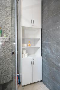 a white cabinet in a bathroom with a shower at Skopje Hostel in Skopje