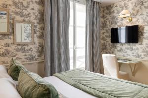 パリにあるホテル デュ シャン ドゥ マルスのベッドと窓が備わるホテルルーム