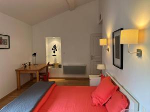 a bedroom with a red bed and a desk at Les Terrasses Binel à Ronsac in Aigrefeuille