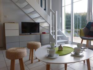 ein Wohnzimmer mit einem Tisch und Stühlen sowie einem TV in der Unterkunft Maison L'Aiguillon-sur-Vie, 4 pièces, 6 personnes - FR-1-224-671 in Saint-Révérend