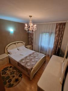 a bedroom with a bed and a chandelier at Vila 33 in Constanţa