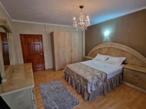 Un dormitorio con una cama grande y una lámpara de araña. en Vila 33 en Constanza