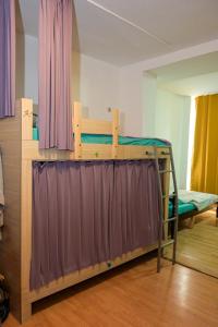 a bunk bed in a room with purple curtains at Skopje Hostel in Skopje