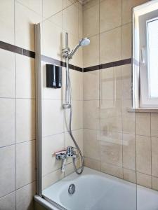 a shower in a bathroom with a bath tub at Bavaria Home: Terrasse, Küche, Netflix in Wolnzach +26 photos