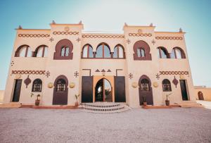 a large building with stairs in front of it at Riad Merzouga Dunes in Merzouga