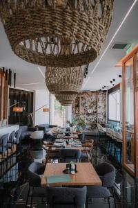 a restaurant with tables and chairs under a large chandelier at Agamemnon Hotel in Nafplio