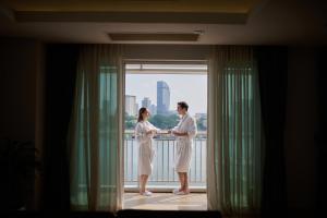 een man en vrouw die voor een raam staan bij Bellevue Serviced Apartments in Phnom Penh