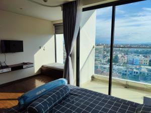 um quarto com uma cama azul e uma grande janela em Hoa vàng trên cỏ xanh em Phu Yen