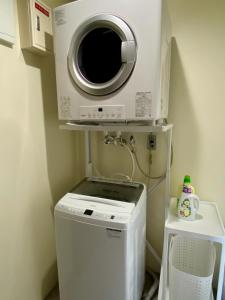 een wasmachine en droger in een kleine kamer bij Sky Blue Villa沖縄 in Jima