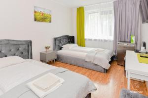 una camera d'albergo con 2 letti e una scrivania di Guest House Simona a Lazdijai