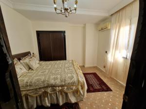 een slaapkamer met een bed en een kroonluchter bij Luxury apartment 2 in the heart of Gueliz, Wifi, Pool in Marrakesh