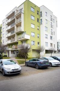 tres autos estacionados en un estacionamiento frente a un edificio en Citilife Apartament dla 4 osób, en Gdansk