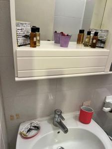 y baño con lavamanos, espejo y lavamanos. en Alloggio ad uso turistico Piave 47- Charlotte's Houses, en Gradoli