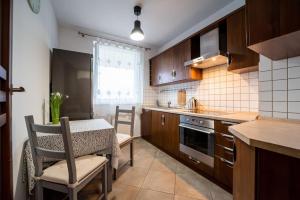 una pequeña cocina con mesa, mesa y sillas en Citilife Apartament dla 4 osób, en Gdansk