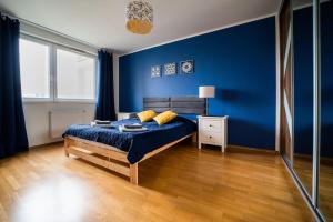 Dormitorio azul con cama y pared azul en Citilife Apartament dla 4 osób, en Gdansk