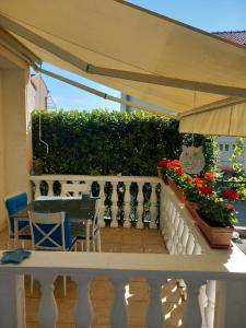 einen Tisch und Stühle auf einem Balkon mit Sonnenschirm in der Unterkunft Studio apartman MARIJA in Petrcane
