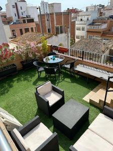 a rooftop patio with grass and chairs and a table at Royal Inn Aparthotel in Lloret de Mar