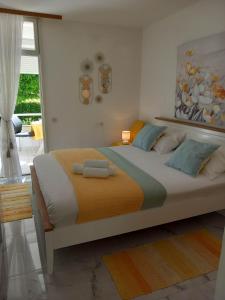 een slaapkamer met een groot bed met oranje en blauwe kussens bij Studio apartman MARIJA in Petrcane