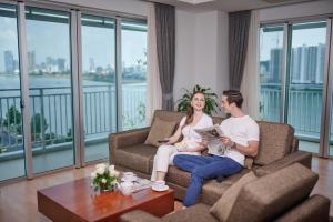 a man and a woman sitting on a couch in a living room at Bellevue Serviced Apartments in Phnom Penh