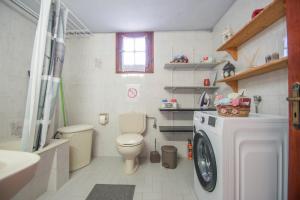 a bathroom with a toilet and a washing machine at SOHORO Forest Hill Apartment in Kampion