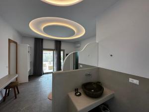 a bathroom with a sink and a large mirror at Abelos Mykonos in M&yacute;konos City