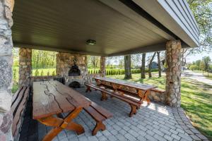 a patio with a picnic table and a stone fireplace at Reketijos Dvaras in Reketija