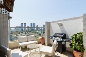 a grill on a balcony with a view of a city at Downtown apartment 3BDR with city view in Giv‘at Rambam
